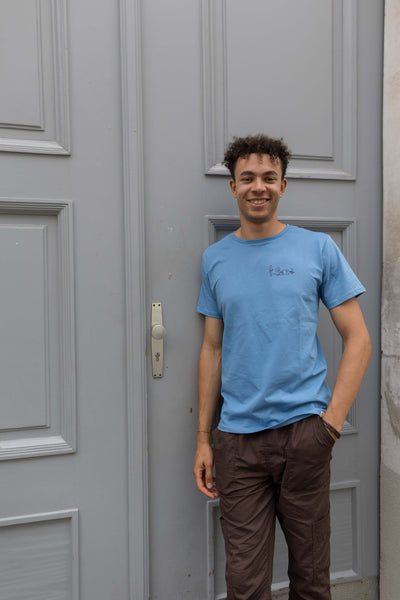 Mann in nachhaltigem blauen Shirt vor Tür