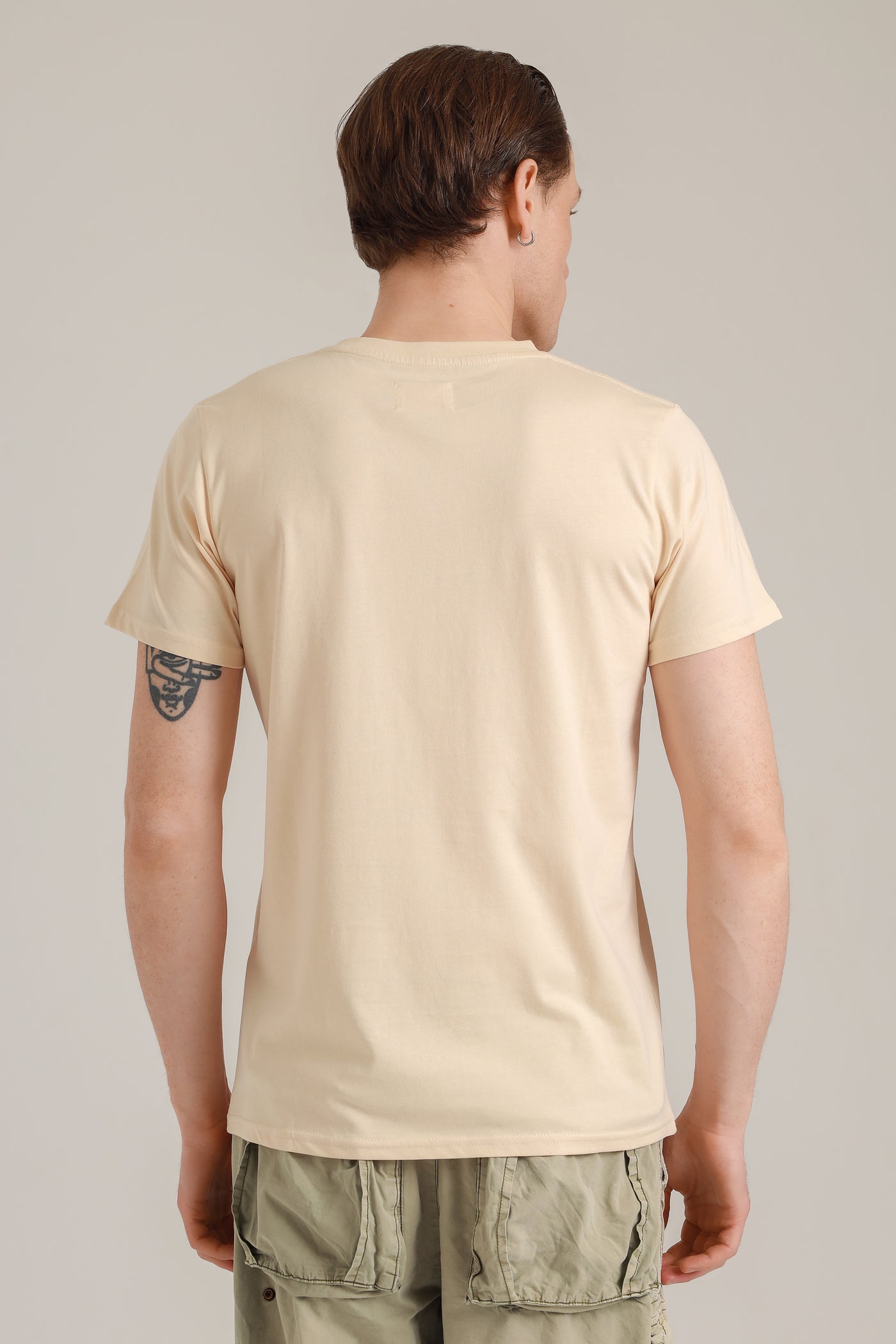 Mann mit nachhaltigem Shirt in Beige mit Insel-Motiv aus Wien von hinten