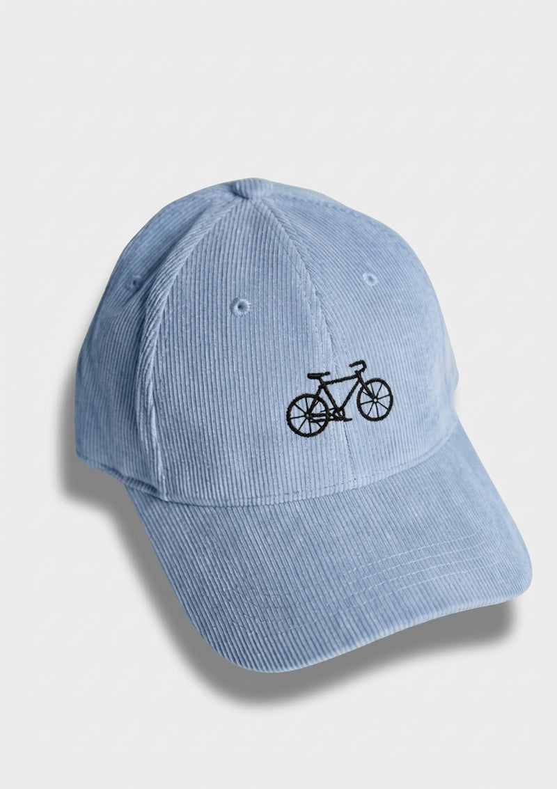 BIKE Kappe: Auf dem Foto: hellblaue Bio-Baumwoll-Kappe (kord) mit besticktem Fahrrad (mountainbike). Das Fahrrad ist mit schwarzer Farbe gestickt. – Produktfoto von Ungerade Wien