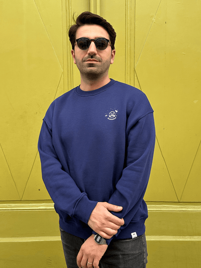 Mann in fairem Sweatshirt in Dunkelblau mit SpaceCat-Motiv aus Wien 