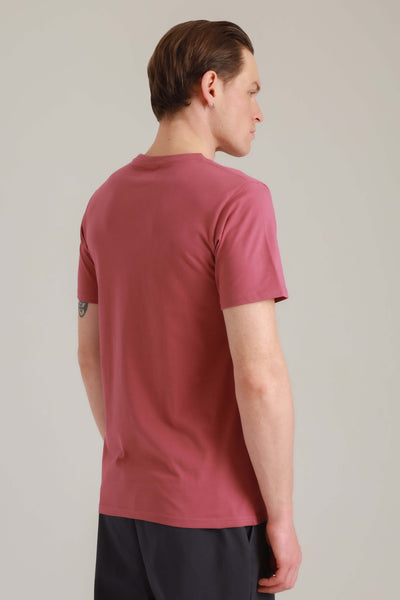 Mann in Fairem Shirt in Rosa mit Rad-Motiv von hinten seitlich