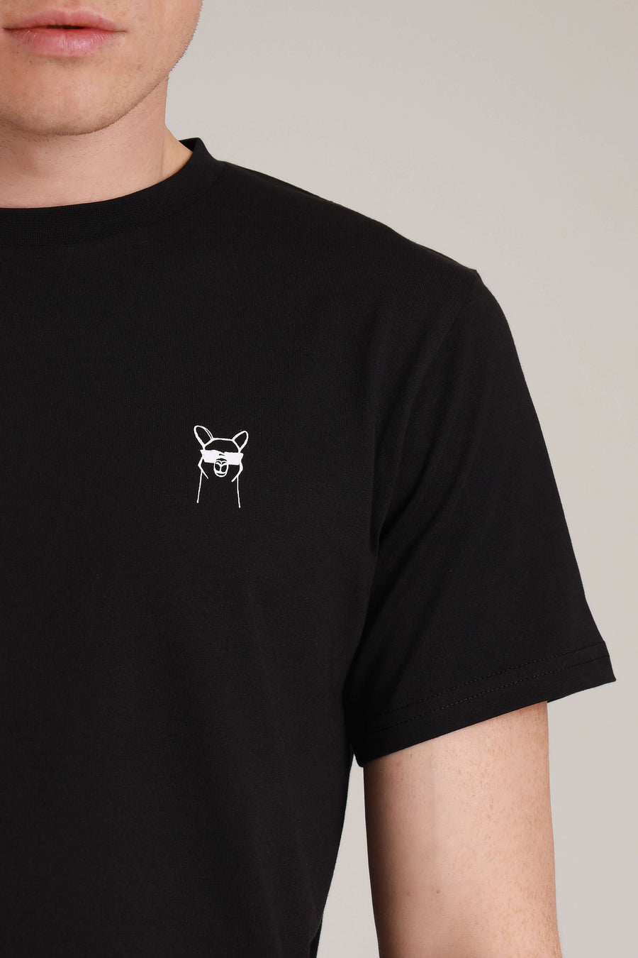 Nachhaltige Mode Wien: von vorne Mann trägt schwarzes Cool Paka T-Shirt, umweltfreundliches Herren-Outfit