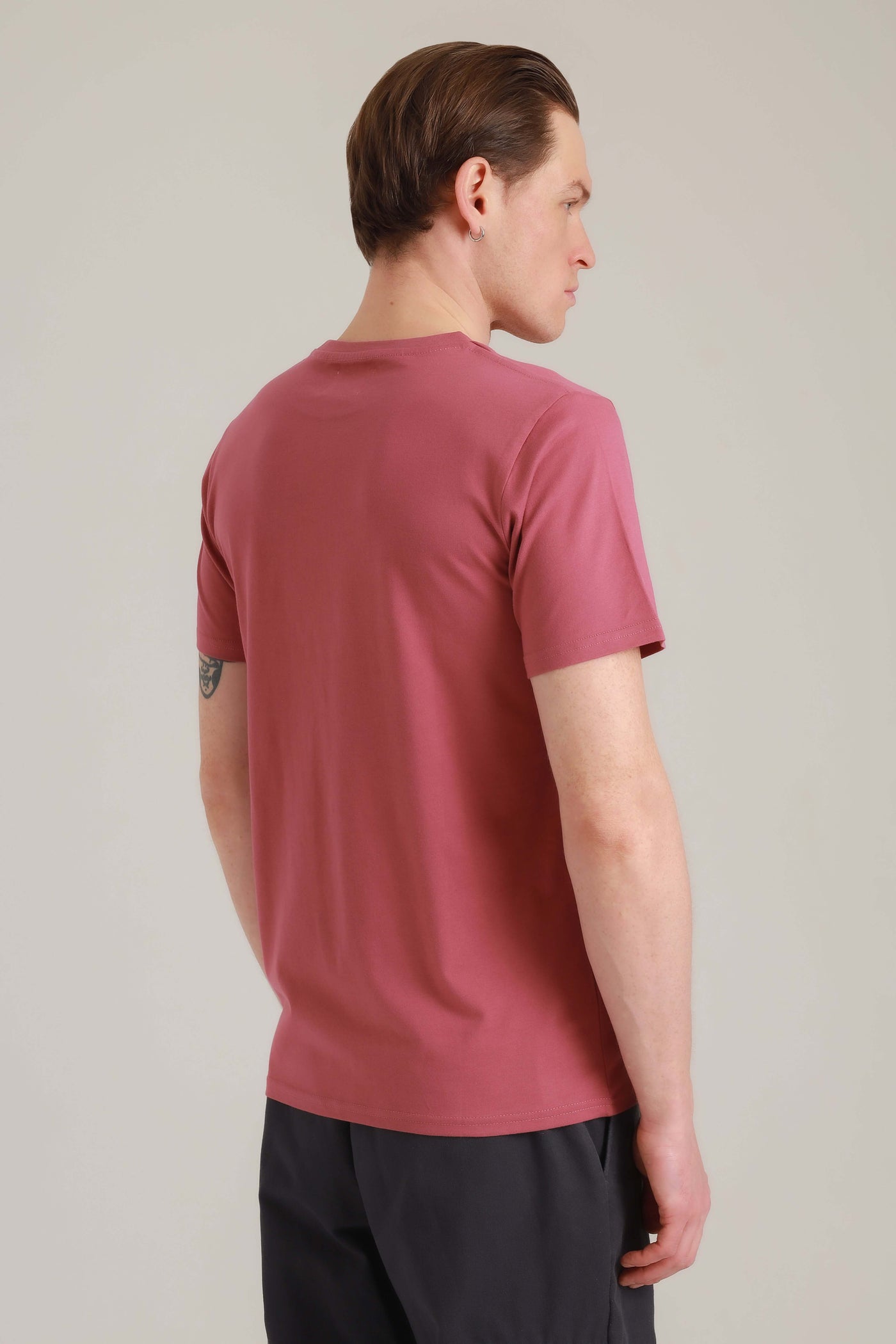 Mann in fairem Shirt in Rosa mit Cool Paka-Motiv von hinten